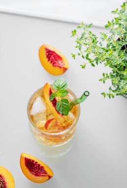 Buzlu şeftalili limonata ve beyaz arka planda nane şekeri. Taze buzlu çay ve camdan gelen ışık. Bar ya da kafe menüsü için yaz içeceği tarifi konseptini tazeliyorum. Üst görünüm