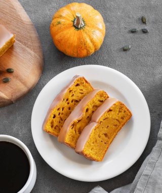 Süslü balkabakları ve bir fincan kahveyle koyu arkaplanda kremalı balkabağı ya da pasta. Kahvaltı için ev yapımı sonbahar pişirme konsepti. Üst görünüm.