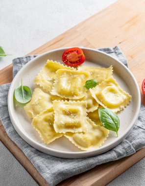 Peynirli, domatesli ve fesleğenli ev yapımı ravioli makarnamız var. Geleneksel İtalyan yemeği konsepti. Boşluğu kopyala.