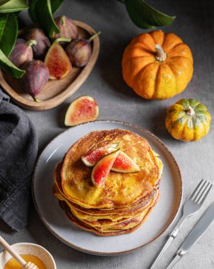 Balkabağı ve ballı gözleme ve taze meyve ve sebzelerle dolu karanlık bir arka planda incir. Ev yapımı sıcacık sonbahar yemekleri kırsal tarzda. Üst görünüm.