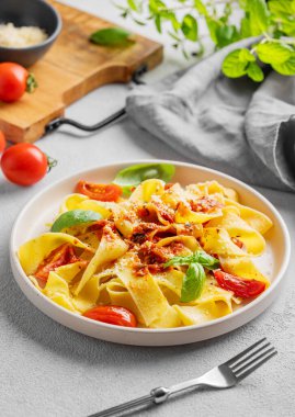 Ev yapımı tagliatelle ya da domates soslu pappardelle makarna, fesleğen ve parmesan peyniri peçeteli, otlu ve çatallı bir tabakta. Geleneksel İtalyan yemeği konsepti. 