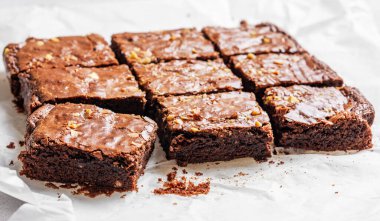 Çikolatalı kek ve fındıklı kek. Sabah ışıklarıyla yakın plan kek kağıdında dilimlenmiş. Ev yapımı sağlıklı pişirme konsepti. 