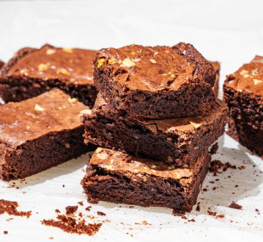 Çikolatalı kek ve fındıklı kek. Sabah ışıklarıyla yakın plan kek kağıdında dilimlenmiş. Ev yapımı sağlıklı pişirme konsepti. 