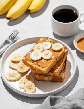 Hafif arka planda muzlu fıstık ezmeli tost bir fincan espresso kahve, gölge ve meyveli. Amerikan kahvaltısı için tatlı beslenme ve sağlıklı atıştırmalıklar kavramı. 