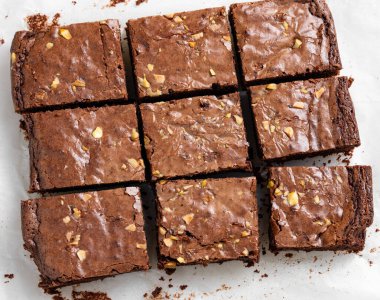 Çikolatalı kek ve fındıklı kek yakın çekim kağıdında dilimlenmiş. Ev yapımı sağlıklı vejetaryen pişirme konsepti. Üst görünüm.