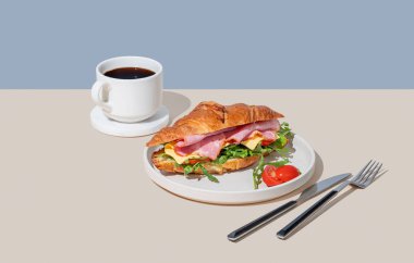 Jambonlu, peynirli, domatesli ve roka arkaplanlı kruvasan sandviçi ve bir fincan taze kahve. Sağlıklı bir kahvaltı ya da brunch kafe menüsü. Boşluğu kopyala