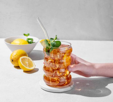 Limonlu, buzlu ve nane arkaplanlı, gölgeli ve narenciyeli bir bardak buzlu çay. Moda olan moktail içeceği ya da limonata. Boşluğu kopyala.