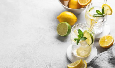 İki bardak mojito kokteyli. Taze limon, limon, nane ve buzlu. Güneş ışığı ve meyveli. Modaya uygun bir yaz konsepti narenciye kokteyli. Üst görünüm ve kopyalama alanı.