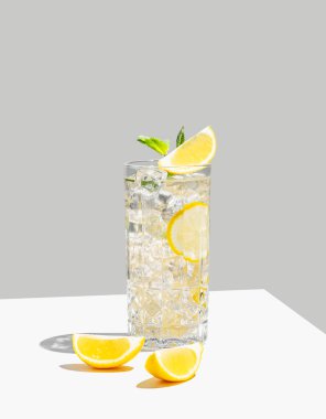 Limon, nane ve buzla mocktail 'i tazeleyen gölgeli beyaz bir arka planda uzun bir bardakta. Yaz turunçgil içeceği ya da kafe reklamları için limonata konsepti. Ön görünüm ve boşluk kopyala