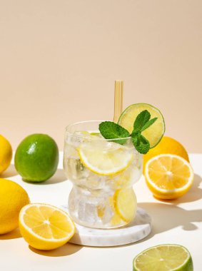 Limonlu, limonlu, naneli ve buzlu taze limonata. Beyaz bej arka planda meyveli Citrus kokteyli mojito. Bar menüsü reklamları veya afişler için yaz modasına uygun içecek konsepti. Boşluğu kopyala.