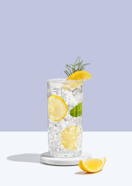 Limonlu limonata, biberiye ve buzlu beyaz mavi arka planda gölgeli bir bardak. Yaz turunçgil içeceği ya da kafe reklamları için mojito kokteyli konsepti. Boşluğu kopyala.