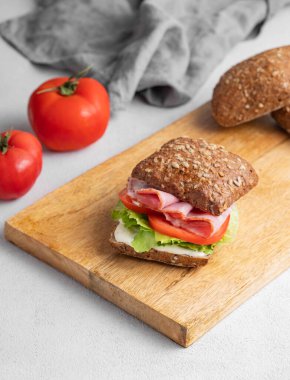 Prosciutto, peynir, domates, marul ve sostan yapılmış tahtadan yapılmış ekmek kızartma sandviçi. Sağlıklı ve diyet kahvaltı konsepti. Boşluğu kopyala.