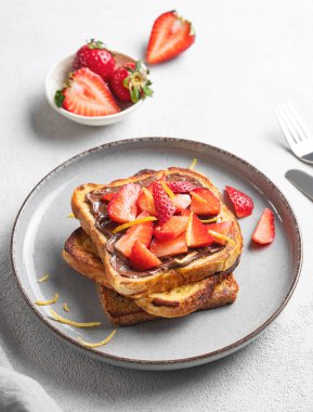Hafif bir zemin üzerinde çikolata kremalı ve çilekli kızarmış ekmek ve taze böğürtlen. Lezzetli ve besleyici ev yapımı kahvaltı kavramı. Boşluğu kopyala.
