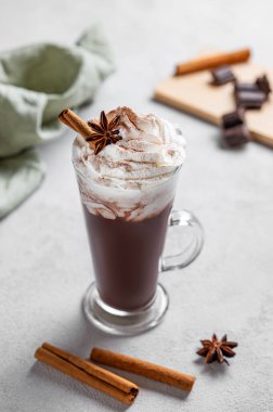 Krem şantili sıcak çikolata, tarçınlı ve baharatlı uzun bir bardakta güneş ışığıyla birlikte. Tatlı içecek konsepti. 