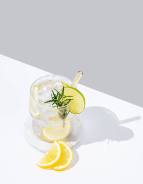 Limonlu, limonlu, biberiyeli ve buzlu taze limonata. Beyaz gri arka planda Citrus kokteyli mojito. Bar menüsü reklamları veya afişler için yaz modasına uygun içecek konsepti. Boşluğu kopyala.