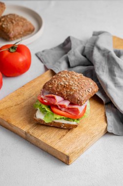 Prosciutto, peynir, domates, marul ve sostan yapılmış tahtadan yapılmış ekmek kızartma sandviçi. Sağlıklı ve diyet kahvaltı konsepti. Boşluğu kopyala.