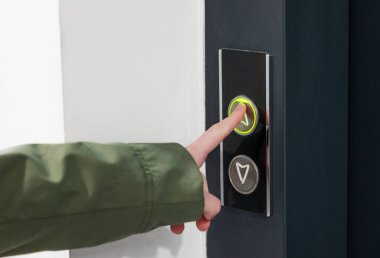 Pürüzsüz siyah panel, minimalist gerçek kapalı ortam, erişim konsepti üzerinde parmak ışıklı kapı zili düğmesi.