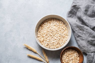 Peçeteli yulaf gevreği ve gri desenli arka planda buğday. Sağlıklı beslenme ve sağlıklı diyet kahvaltı konsepti. Üst görünüm ve kopyalama alanı.