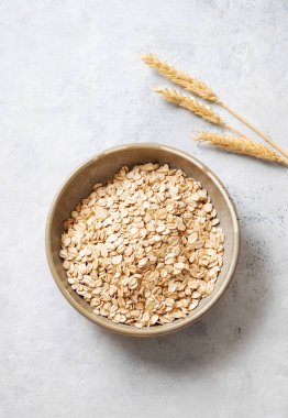 Kasede yulaf gevreği ve hafif desenli arka planda buğday. Sağlıklı beslenme ve sağlıklı diyet kahvaltı konsepti. Üst görünüm ve kopyalama alanı.