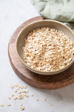 Tahtadaki yulaf gevrekleri ve arka planda hafif desenli peçete. Sağlıklı beslenme ve sağlıklı diyet kahvaltı konsepti. Üst görünüm ve kopyalama alanı.