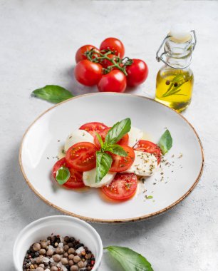 Domatesli Caprese salatası, mozzarella ve taze sebze, yağ ve baharatlı fesleğen. Sağlıklı Akdeniz mutfağı konsepti. Boşluğu kopyala.