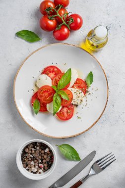 Dilimlenmiş domatesli taze Caprese salatası, mozzarella peyniri, fesleğen yaprağı ve peçeteli bir tabakta balzamik jöle. Sağlıklı beslenme konsepti. Üst görünüm ve kopyalama alanı.