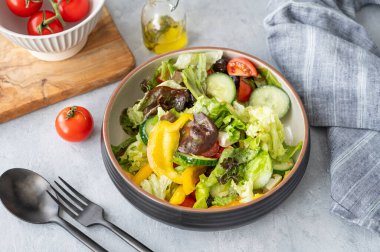 Salatalı, domatesli, salatalıklı, zeytinli ve beyaz arkaplanlı sağlıklı sebze salatası. Taze ve doğal diyet gıda konsepti. Üst görünüm.