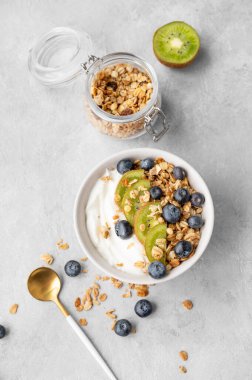 Mısır gevreği, kivi ve yabanmersinli yoğurt ve taze böğürtlen ve fırınlanmış yulaf ezmesi. Sağlıklı ve besleyici kahvaltı konsepti. Üst görünüm ve kopyalama alanı.
