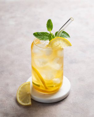 Limonlu buzlu çay ve narenciye dilimli hafif arka planda bir bardakta nane. Yaz günü ferahlatıcı içecek ya da limonata konsepti. Boşluğu kopyala.