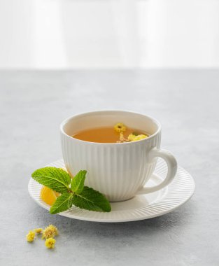 Bir bardak limonlu bitki çayı. Pencere arkasındaysa sabah ışığı var. Kahvaltıda sağlıklı vitamin içeceği kavramı. Boşluğu kopyala.