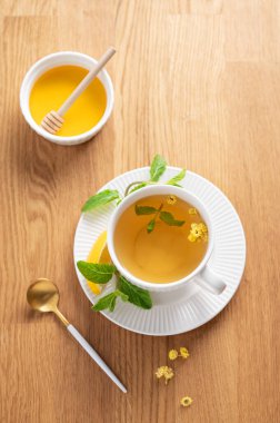 Limonlu, ballı ve nane şekerli bir fincan bitki çayı narenciye meyveli ve sabah ışığı. Kahvaltıda sağlıklı detoks içeceği kavramı. Üst görünüm, alanı kopyala.