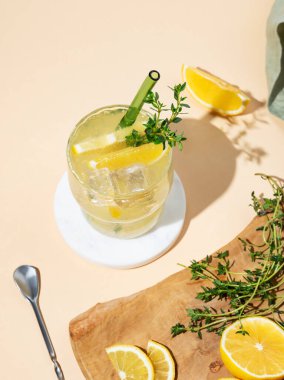 Mocktail mojito 'yu limon, limon, kekik ve buzla tazeliyorum. Sarı arka planda meyveli turunçgil limonatası. Yaz modasına uygun soğuk içecek konsepti. Üst görünüm, alanı kopyala.