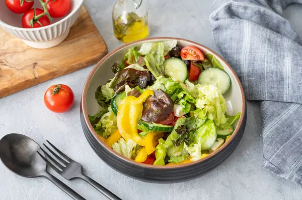 Salatalı, domatesli, salatalıklı, zeytinli ve beyaz arkaplanlı sağlıklı sebze salatası. Taze ve doğal diyet gıda konsepti. Üst görünüm.