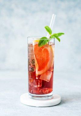 Mavi arka planda, greyfurt, nane ve buzlu, doğal ışıkla serinletici bir kokteyl. Yaz turunçgil içeceği ya da kafe reklamları için limonata konsepti. Ön görünüm, boşluğu kopyala.