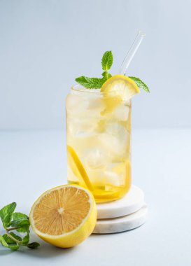 Limonlu buzlu içecek ve nane şekeri mermer tezgahın üzerinde narenciye ve otlarla birlikte. Bir yaz günü soğuk çay ya da limonata konsepti. Ön görünüm, boşluğu kopyala.
