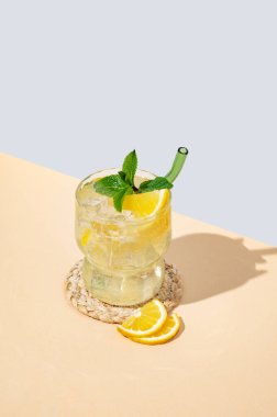 Limonlu mocktail mojito, naneli ve buzlu. Mavi sarı arka planda turunçgil limonatası. Barın reklam ve afişi için yaz modasına uygun içki konsepti. Boşluğu kopyala.