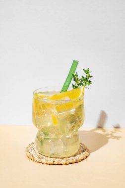 Limonlu taze limonata, naneli mojito ve gölgeli sarı bir zemin üzerinde buz. Barın reklam ve afişi için yaz modasına uygun içki konsepti. Ön görünüm, boşluğu kopyala.