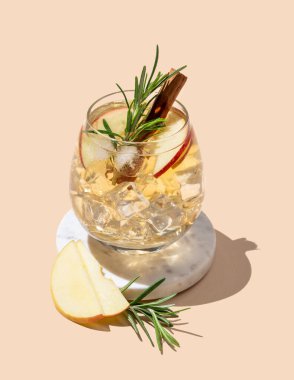 Elma kokteyli ya da bej arka plandaki mermer tezgahta buzlu, tarçınlı ve biberiyeli elma şarabı. Reklamcılık ya da bar menüsü afişi için canlandırıcı içecek konsepti. Boşluğu kopyala