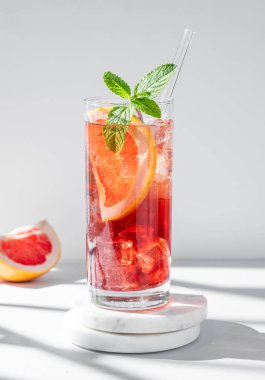 Greyfurt, nane ve buzla serinletici bir kokteyl mermer tezgahında gölgeli bir şekilde. Yaz turunçgilleri ya da limonata konsepti. Ön görünüm ve boşluk kopyala.