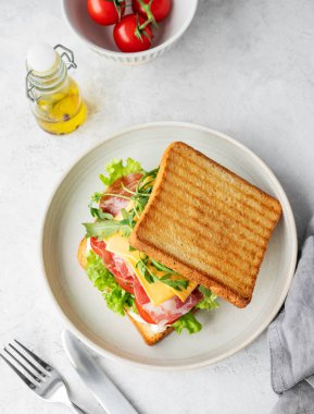 Pastırmalı, peynirli, domatesli, marullu, roka soslu ve yağlı bir tost sandviçi. Sağlıklı ve besleyici kahvaltı konsepti. Üst görünüm, alanı kopyala.