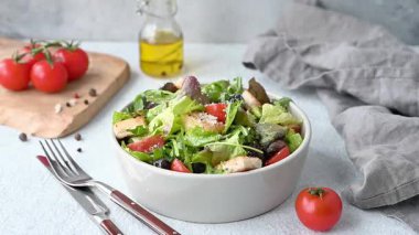 Salatalı, domatesli, kızarmış ekmekli, zeytinli vejetaryen salatası ve arka planda hafif sebzeli, yağlı ve çatallı parmesan peyniri. Sağlıklı beslenme konsepti. Ön görünüm, boşluğu kopyala.