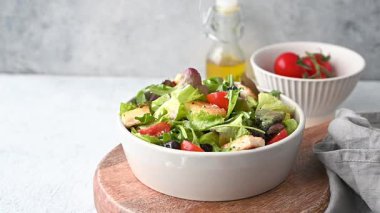 Salatalı, domatesli, kızarmış ekmekli, zeytinli vejetaryen salatası ve arka planda hafif sebzeli, yağlı ve çatallı parmesan peyniri. Sağlıklı beslenme konsepti. Ön görünüm, boşluğu kopyala.