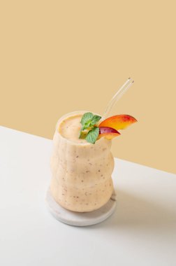 Sıcak, aydınlık bir odada elinde limonlu ve otlu çay tutan bir kadın. Kahvaltı ve sağlıklı beslenme konsepti. Boşluğu kopyala.