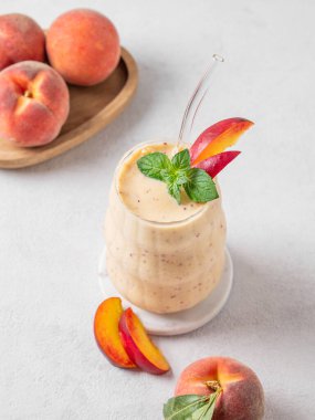 Şeftalili ve muzlu meyve suyu. Arka planda hafif bir bardakta, tropikal meyveli. Reklam menüsü ya da afiş kafe için sağlıklı beslenme ve detoks diyeti kavramı. Üst görünüm, alanı kopyala.