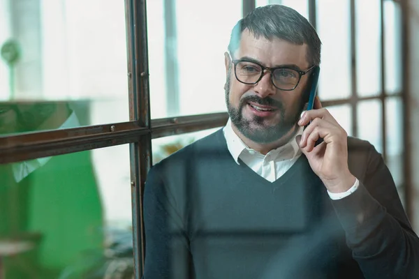 Happy Male Entrepreneur Glasses Speaking Customer Smartphone Office — Stockfoto
