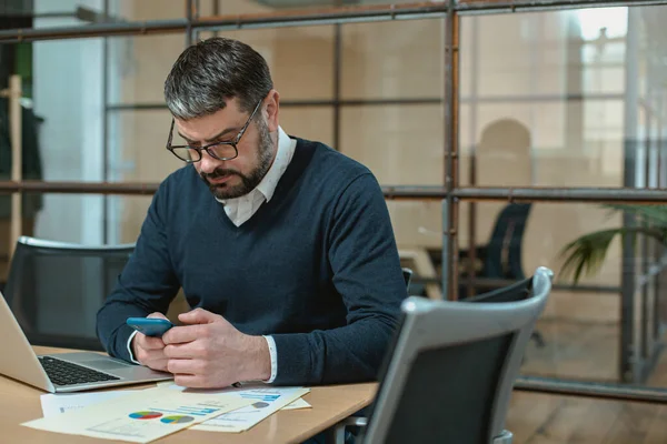 Adult Male Entrepreneur Using Mobile Phone While Sitting Office Imágenes de stock libres de derechos