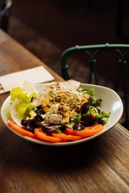 Lokantada servis edilen mozarella domatesleri ve otlarla süslenmiş yüksek açılı lezzetli et.