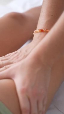 Masöz bir kadının bacağına rahatlatıcı bir masaj yapıyor.