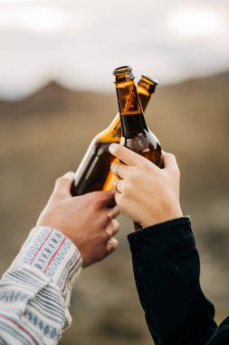 Gezginler, karavan yaşam tarzlarını kutlamak için doğal bir manzarada bira içiyorlar.