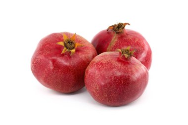 Beyaz zemin üzerinde üç olgun nar meyvesi izole edilmiş.